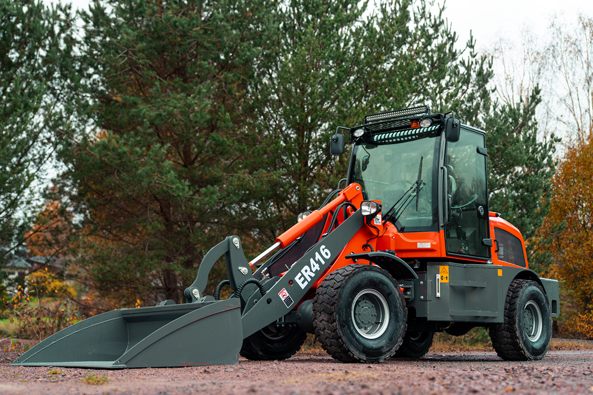 En röd Lastmaskin som står på ett fält